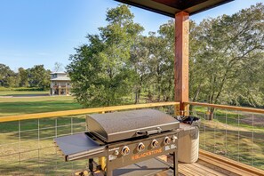 An outdoor grill area with a view of a golf course and a house in the background. - 'river Bank' Spacious Waterfront Group Getaway (Nashville)