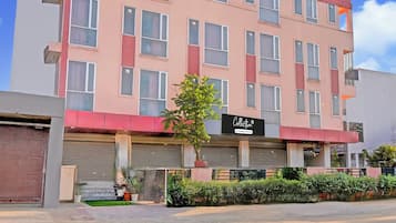 Un immeuble à plusieurs étages, sur lequel est apposée une enseigne indiquant qu’il s’agit d’un point de collecte géré par une entreprise.