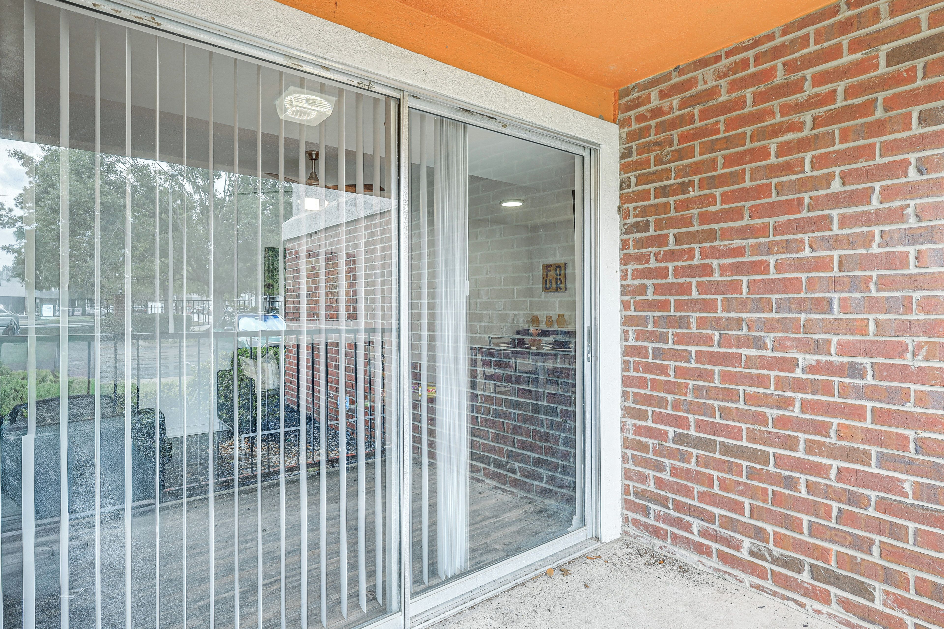 A building with a glass door and a brick wall.