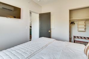 Un dormitorio con una cama, un armario y una puerta.