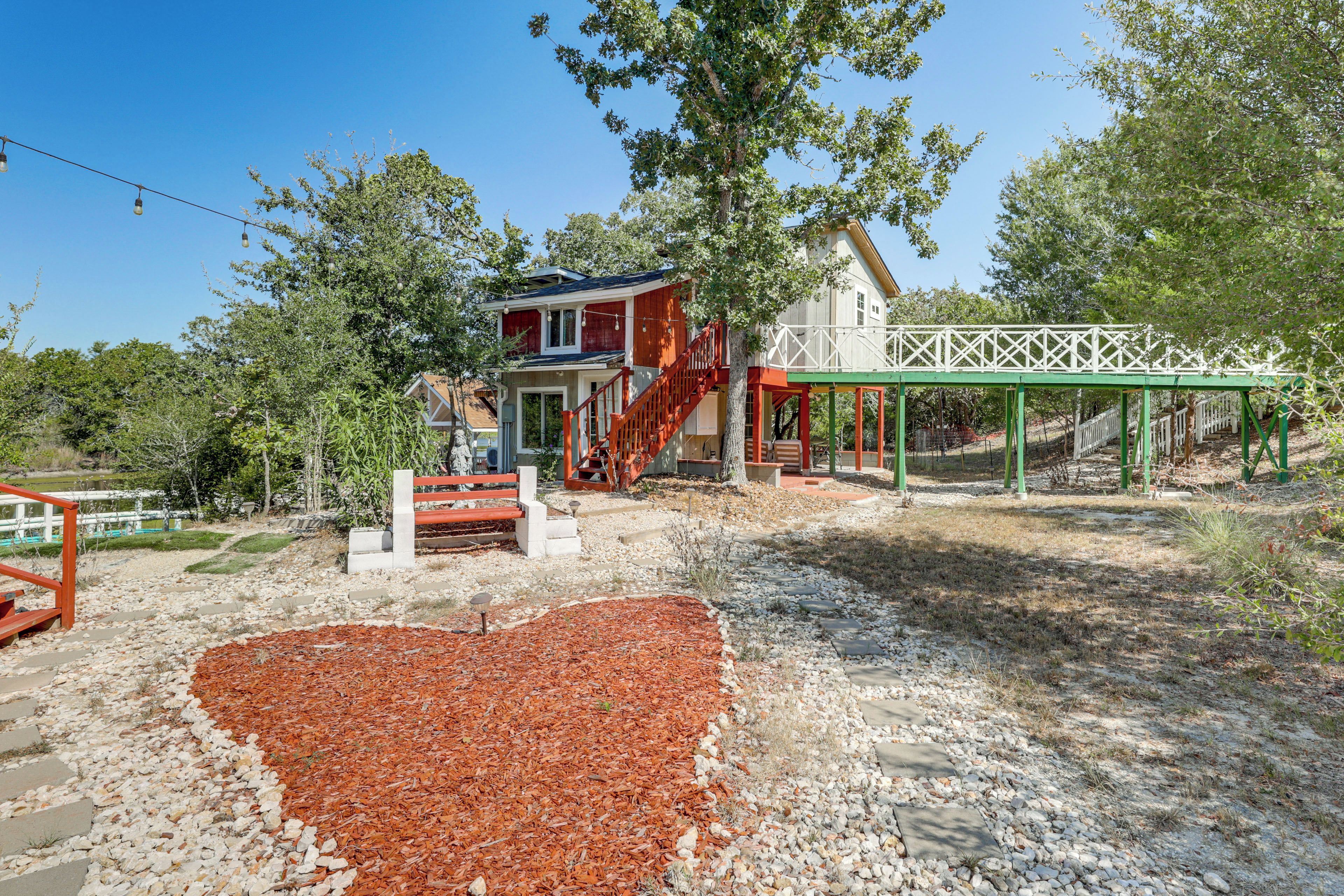 A house with a red exterior, a porch, and a white fence.