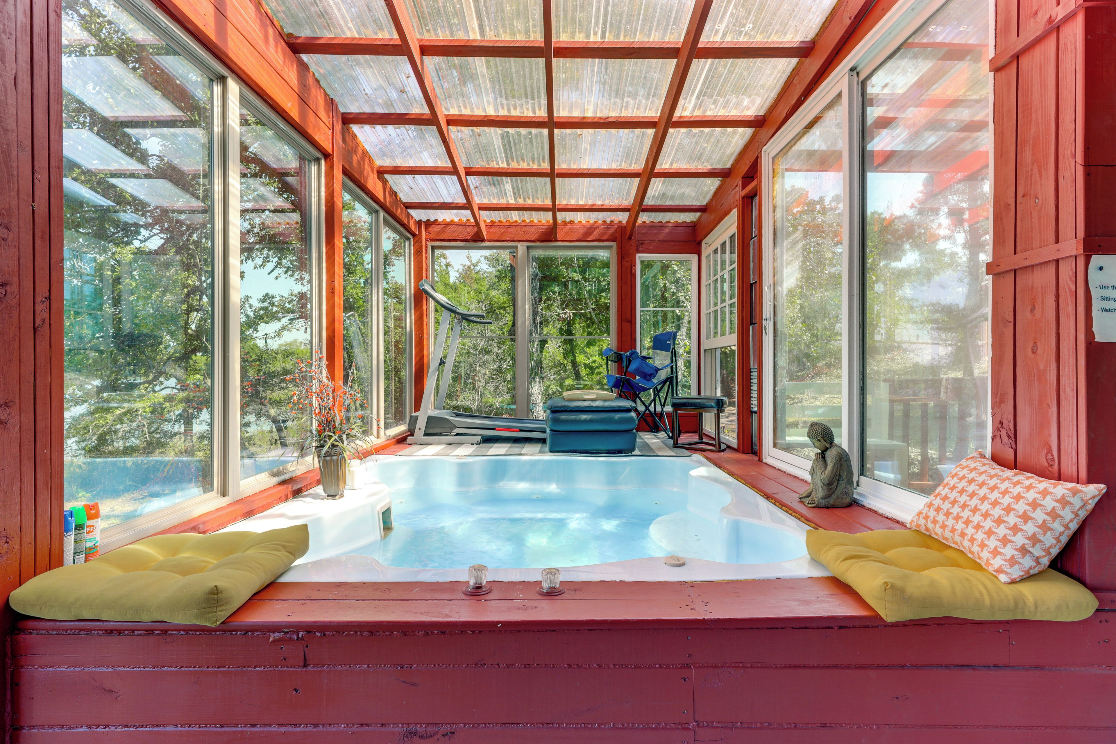 A sunroom with a glass ceiling, a small pool, and seating areas.