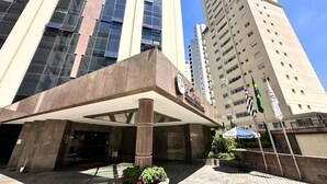 A hotel entrance with a modern design, featuring a large entrance canopy and a prominent logo. - Le Premier Suites (São Paulo)