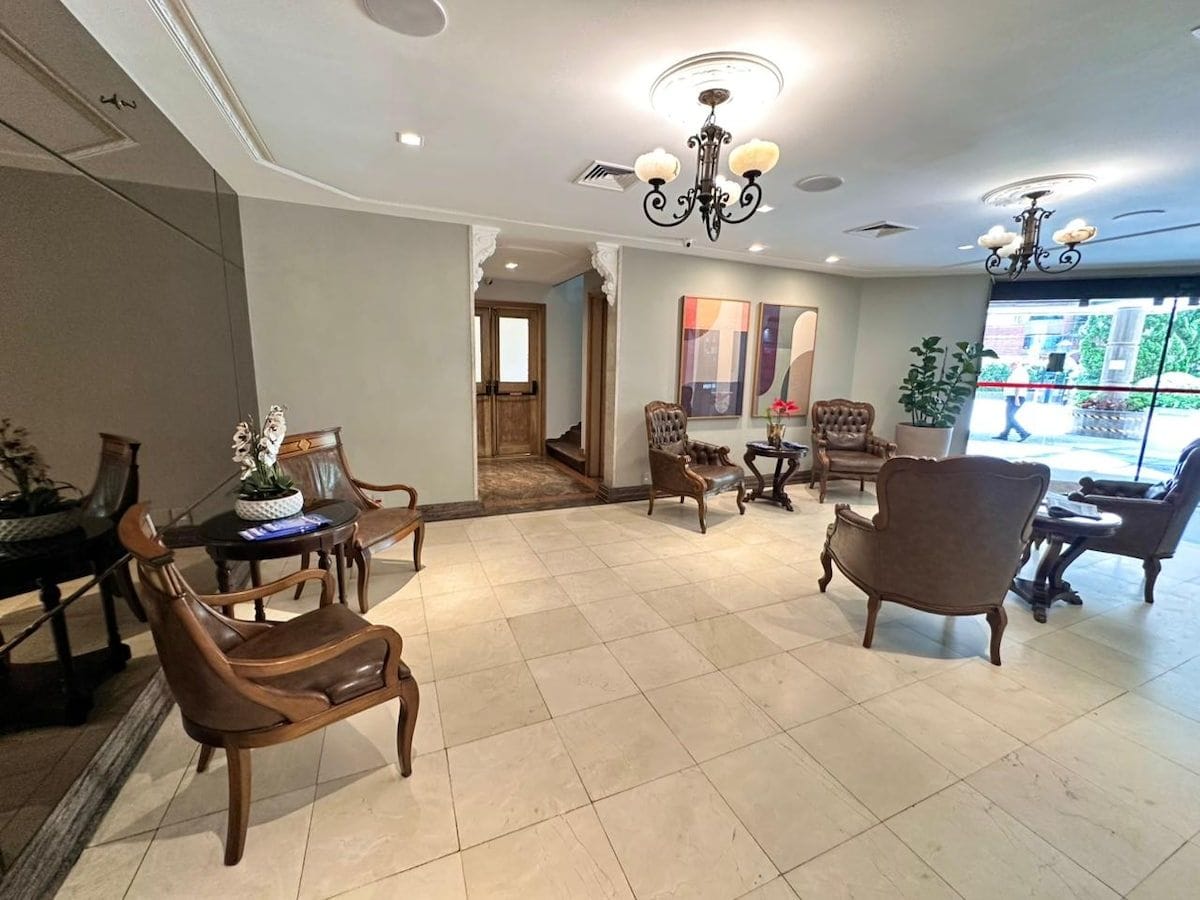 A spacious living area with a dining table, multiple chairs, and a chandelier.
