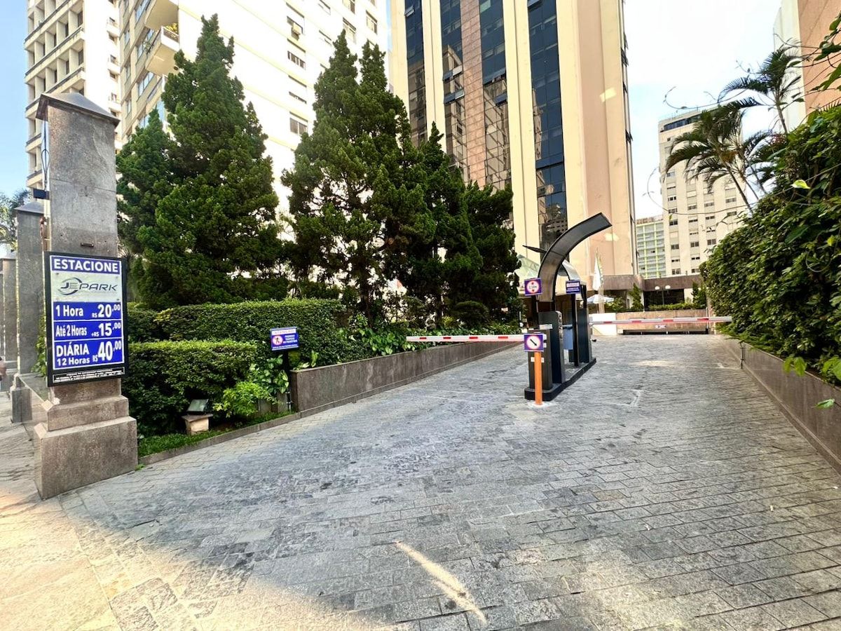 Ingresso recintato verso un'area di parcheggio, con un cartello che indica le tariffe.