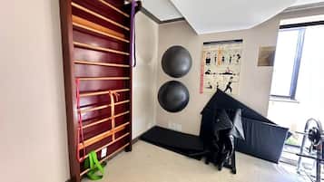 Een sportschool met een houten rek, twee grote fitnessballen en een zwart, gevoerd gebied.