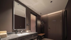 A modern bathroom with a marble sink, a large mirror, a towel rack, and a wooden door. - dalianxinghaiguangchangditiezhanyaduojy (Dalian)