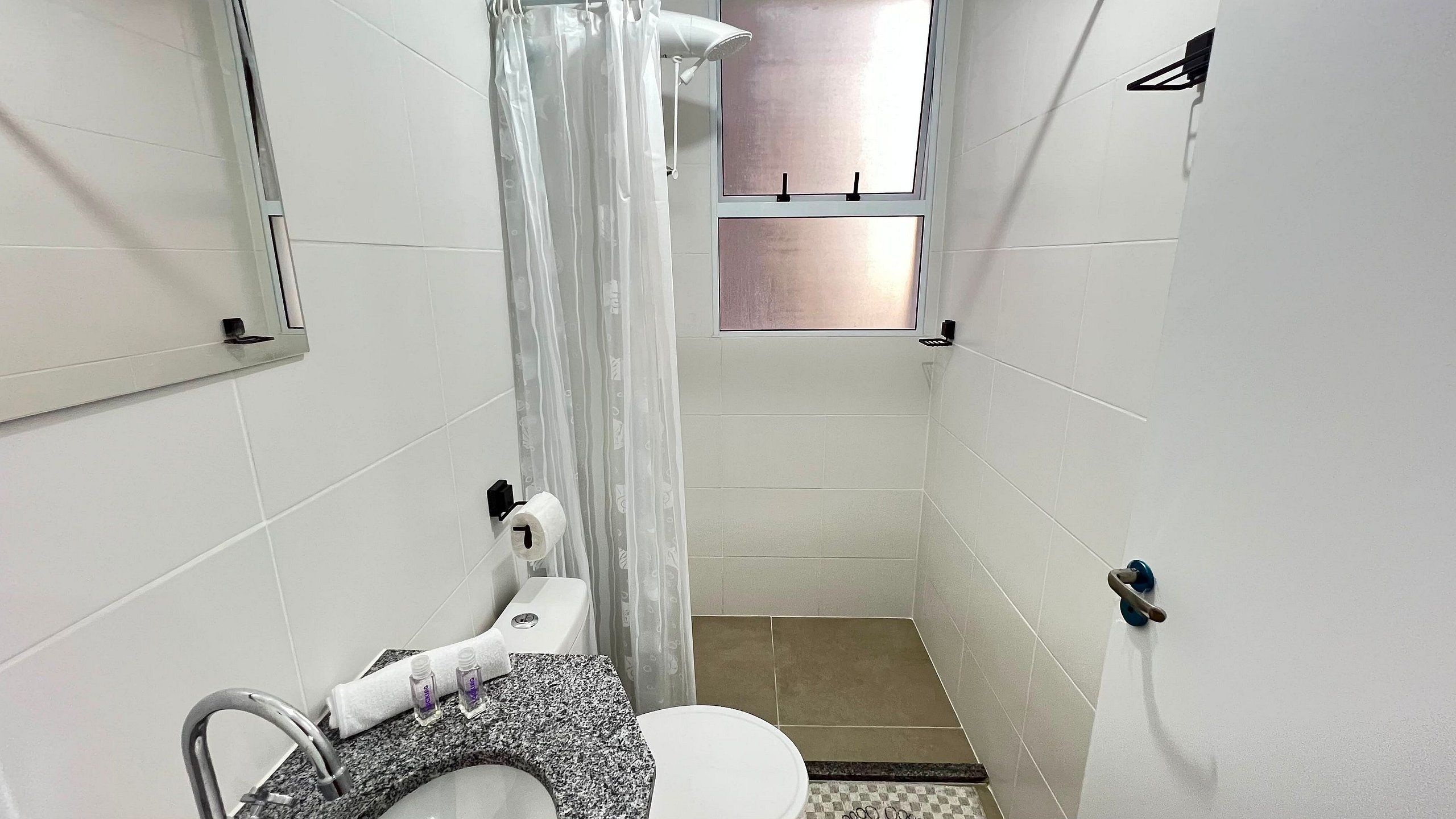 Un baño pequeño con inodoro, lavabo y cortina de ducha.