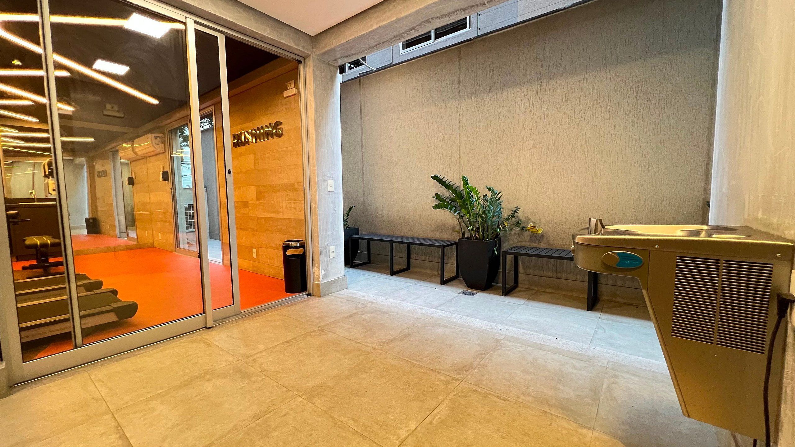 Un interior moderno con una recepción, una escalera y una planta en maceta.