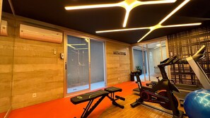 Un gimnasio con equipo de ejercicio, una banca y una pared con un letrero que dice 'RUNNING'.