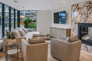 A modern living room with a sofa set, a television, and a fireplace. - The Oak Haven | 2BR+2BA | Central | Pool&Sauna (Kelowna)