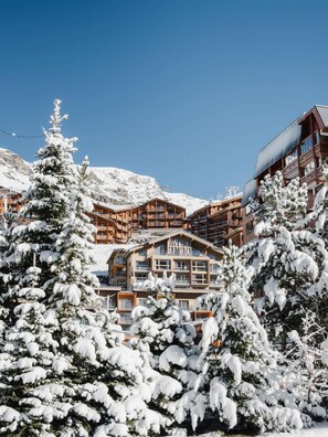 A snow-covered lodge with multiple balconies and a ski lift in the background. - "V22" by Versant Collection (Val Thorens)