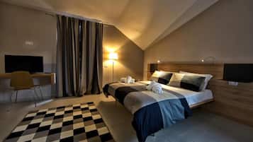 Una habitación de hotel con una cama, un escritorio, una silla, una lámpara y un televisor.