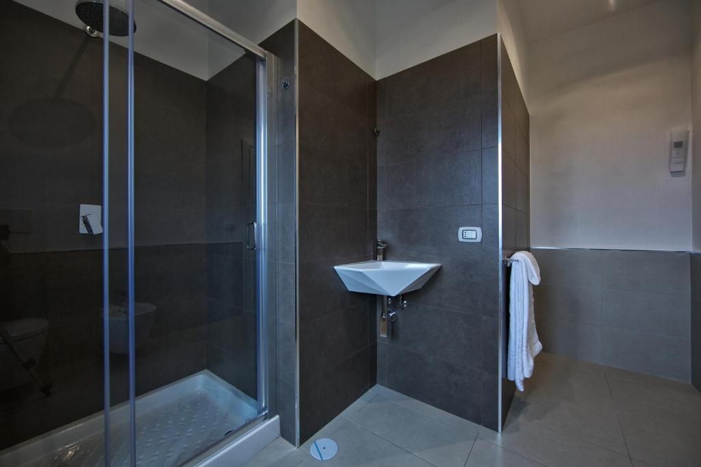 Ein modernes Badezimmer mit einer Duschkabine aus Glas, einem weißen Waschbecken und einem Handtuchhalter.
