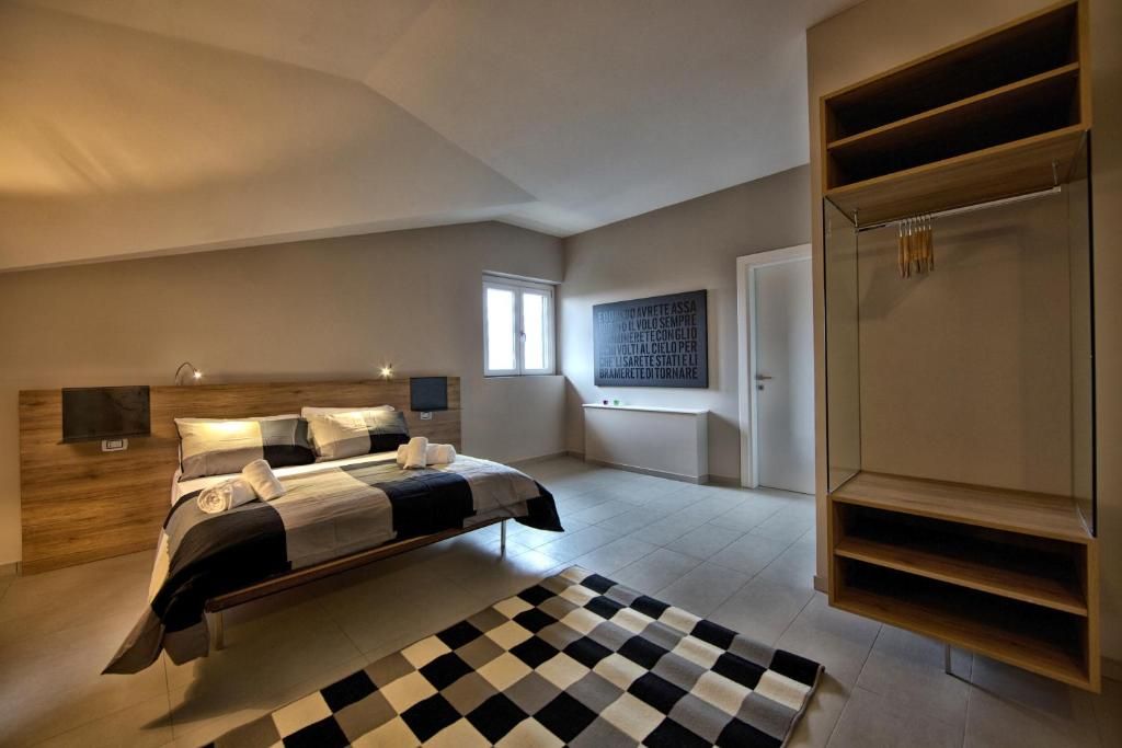 Un dormitorio con cama, mesitas de noche, armario, ventana y una obra de arte colgada en la pared.