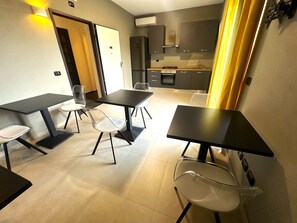 Cozinha moderna com área de jantar, incluindo mesa e cadeiras, e entrada separada.