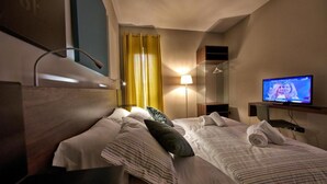 A hotel room with two beds, a television, a mirror, and a window with curtains. - Lepini Suites Guesthouse (Patrica)