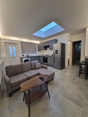 Ein modernes Wohnzimmer mit einer Couch, einem Couchtisch und einer Fernbedienung darauf.