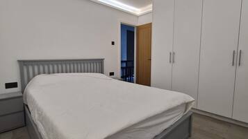 A bedroom with a bed, wardrobe, and a nightstand.