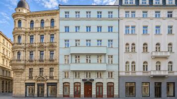 A row of multi-story buildings with classical architecture, featuring ornate facades and large windows.