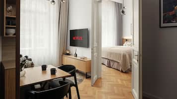 Una habitación de hotel moderna con comedor, televisor y cama.
