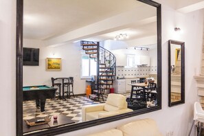 A living room with a pool table, a sofa, and a dining area with chairs and a table. - Stone house in the very center with pool table, two balconies and the sea view (Bol)