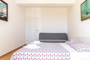 A bedroom with a bed, pillows, a bedside table, and a door. - Stone house in the very center with pool table, two balconies and the sea view (Bol)