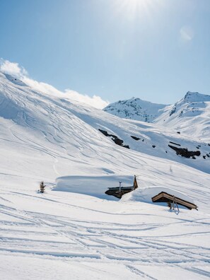 A snow-covered mountain landscape with a small cabin and a ski lift. - "V23" by Versant Collection (Val Thorens)