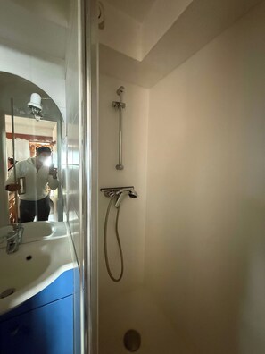 A bathroom with a shower, a sink, and a mirror. - "V23" by Versant Collection (Val Thorens)