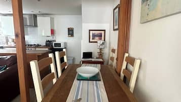 A dining area with a wooden table, chairs, and a striped table runner.