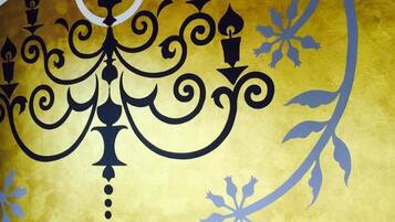 A decorative wall with a central black chandelier design and floral patterns.