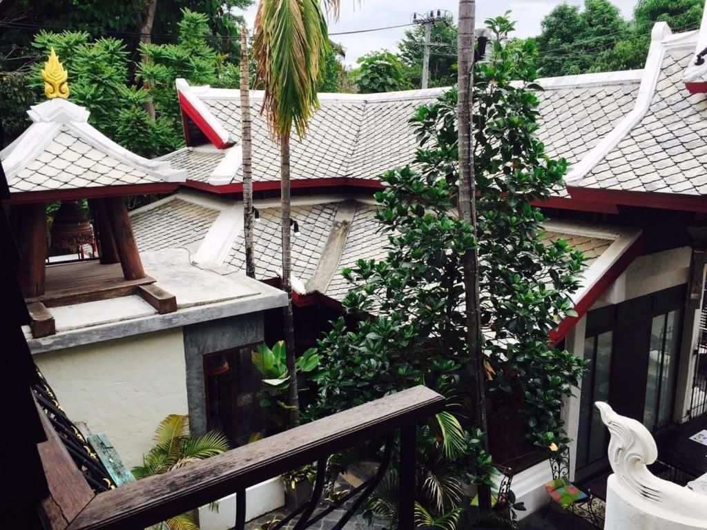 A traditional building with a tiled roof, a wooden bench, and a statue.
