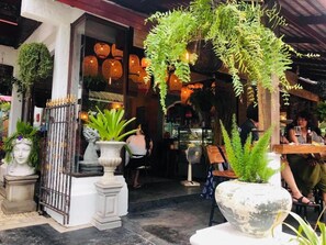 An outdoor seating area with potted plants and a bar. - soi one boutique bedrooms (pai)