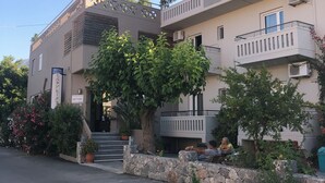 A modern hotel with a flat roof, multiple balconies, and a staircase leading to the entrance. - Labyrinth Hotel (Georgioupoli, Crete)