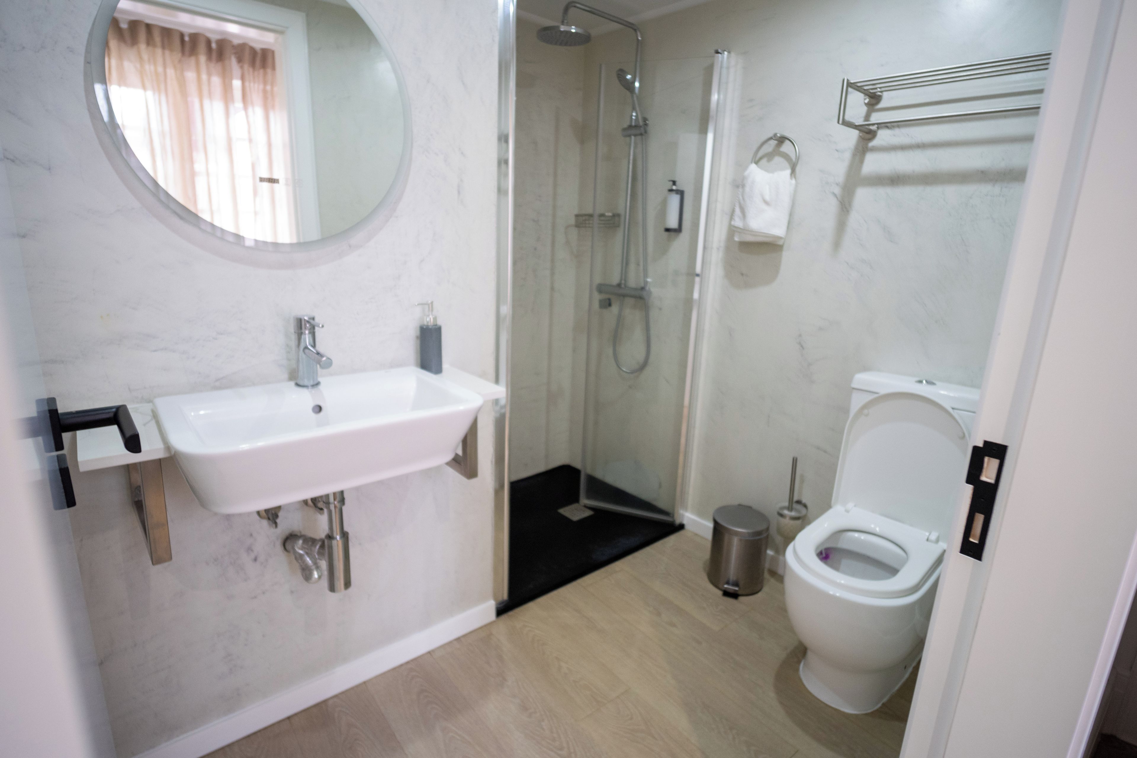 A bathroom with a white sink, a toilet, and a shower area.