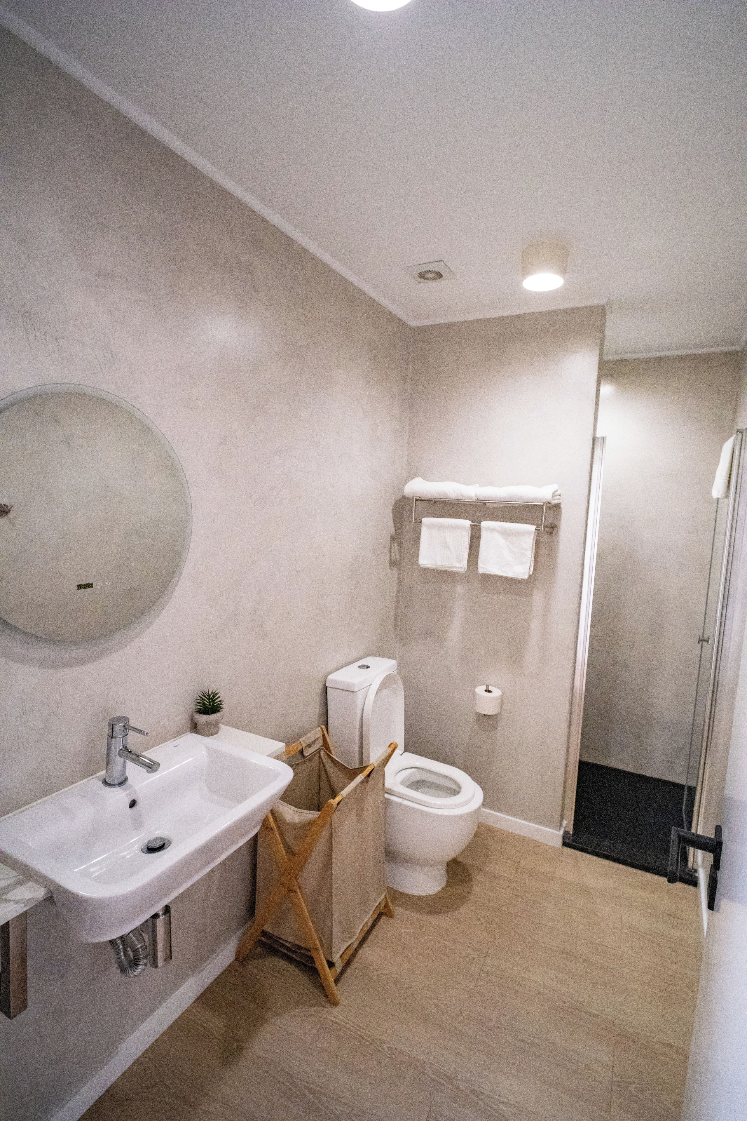 A bathroom with a sink, toilet, and shower area.