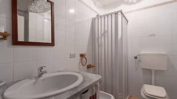 Un bagno con lavabo in marmo, un water e cabina doccia.