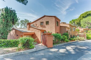 Un edificio residenziale con facciata in stucco, tetto in tegole e ingresso con cancello.
