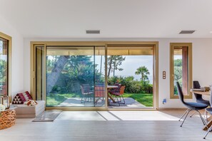 Ein modernes Interieur mit einer Schiebeglastür, die zu einer Außenpatiofläche führt.