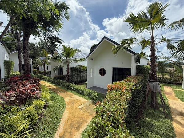 A row of white buildings with a central structure featuring a circular window and a door. - Cozy 1-bedroom bungalow in perfect Phuket with AC included (Phuket)
