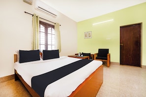 Quarto de hotel com uma cama grande, uma mesa, uma cadeira e um guarda-roupa.
