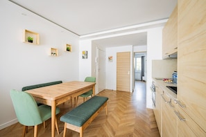 A modern kitchen with wooden cabinets and a built-in oven. - Saint Denis—Metro—3 Bedrooms—Modern—New (Saint-Denis)