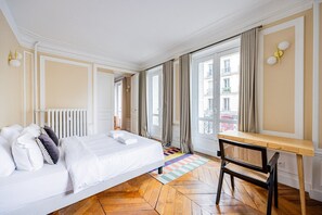 Ein Hotelzimmer mit Bett, Schreibtisch und Blick auf die Stadt.