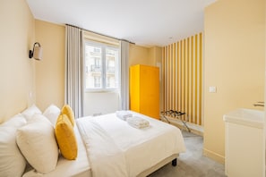 Ein Hotelzimmer mit Bett, Fenster, Kleiderschrank und Badezimmer.