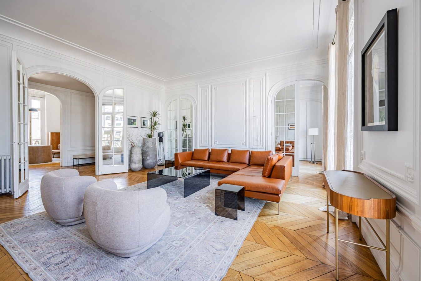 Un salon spacieux avec un canapé d’angle, des poufs et une table basse.