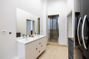A modern bathroom with a large mirror, two sinks, and a shower area. - Parc Monceau - Arc de Triomphe - 5-bedroom - Premium (Paris)