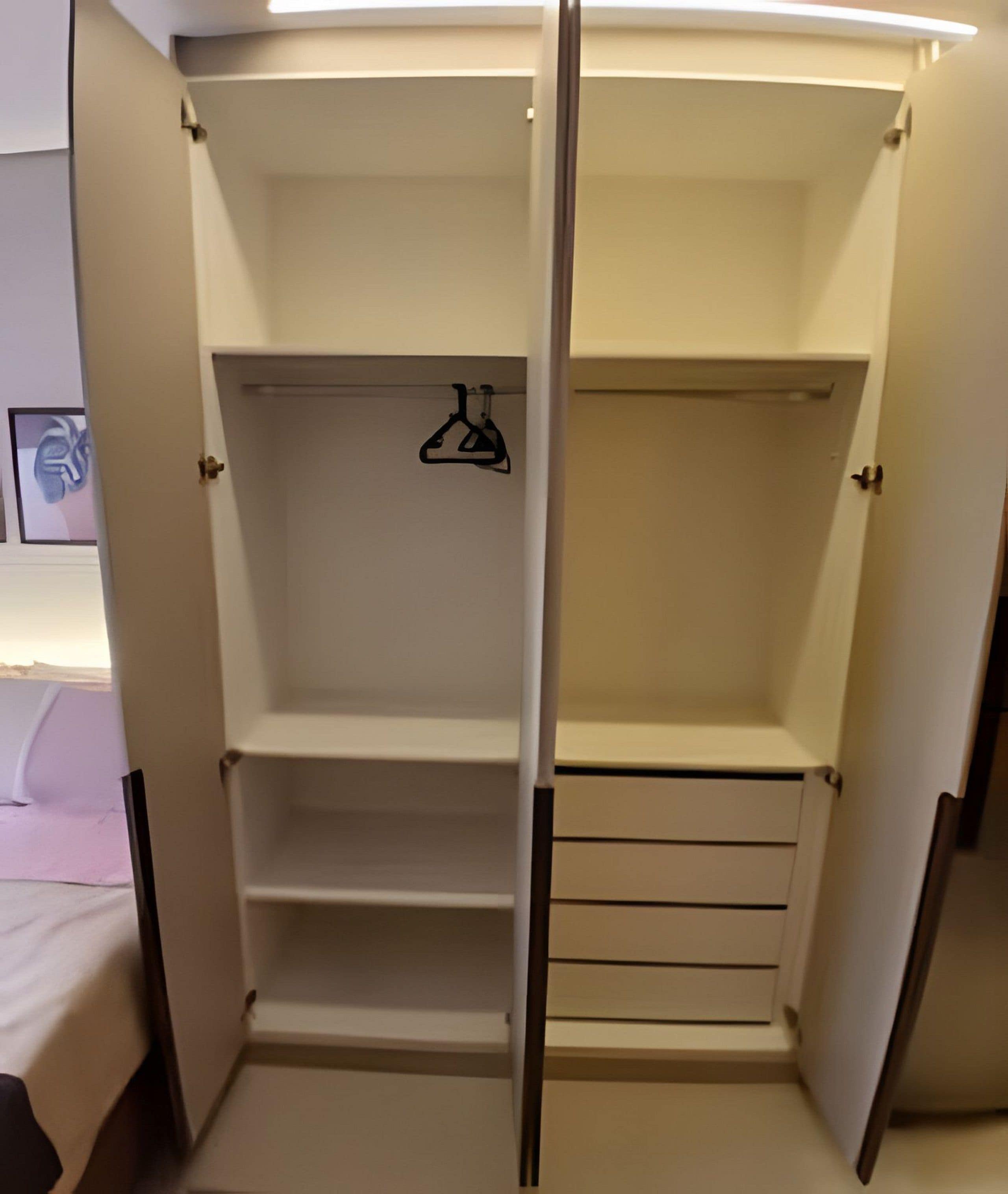 Vestidor amplio con puertas abiertas, con varias estanterías y una barra para colgar.