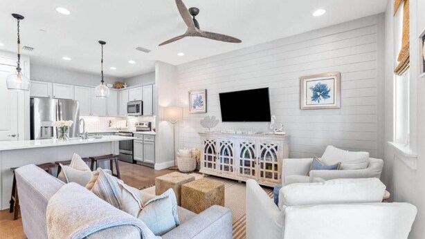 A modern kitchen with white cabinetry, a dining area with a white table, and a living room with a white sofa set. - Seagrove Groove D102-Beach Access-Sleeps 8 (Seagrove Beach)