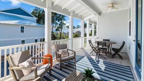 A covered porch with outdoor furniture, a ceiling fan, and a view of neighboring houses. - Seagrove Groove D102-Beach Access-Sleeps 8 (Seagrove Beach)