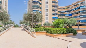 A modern residential complex with multiple balconies, a central walkway, and landscaped areas. - Grazioso Bilocale con Piscina e Terrazza Wi-fi AC (Rome)